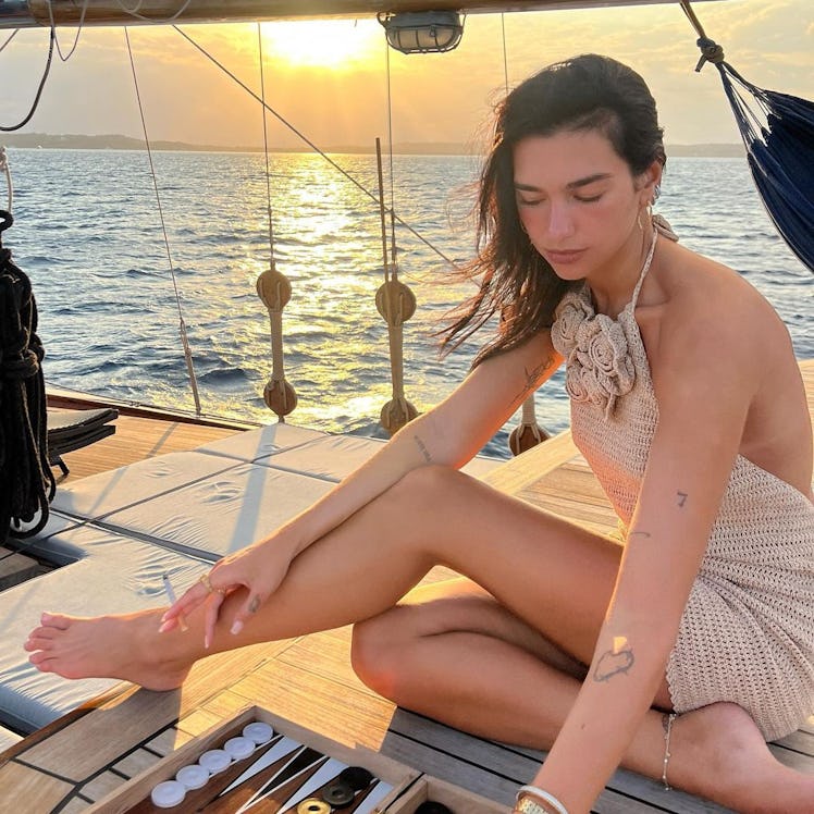 Dua Lipa wears a crochet halter mini dress with rose details in a photo posted to her Instagram.
