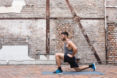 A man doing a lunge for ankle mobility outside.