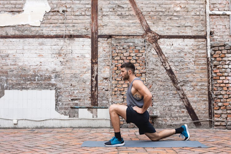 A man doing a lunge for ankle mobility outside.