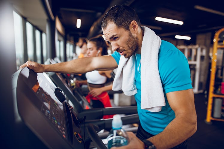 A man trying fasted cardio runs on a treadmill at the gym, on an empty stomach.