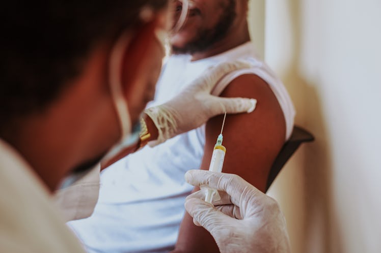 A healthcare worker is about to give a man the flu shot.