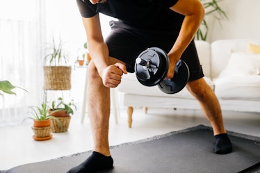 A man doing a dumbbell workout at home.