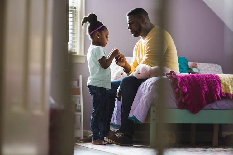 A dad talking to his daughter in her bedroom.