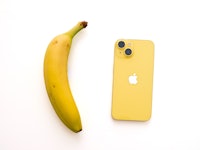 iPhone 14 in yellow next to a banana for a color comparison