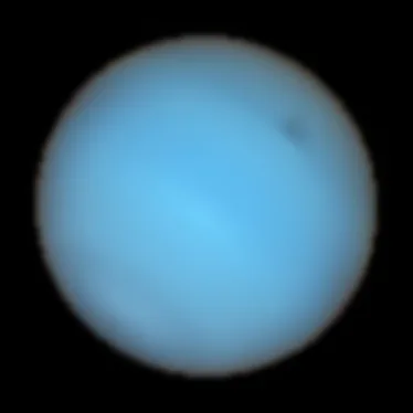 Neptune has a hazy appearance, but on the top right, there is a spot darker than its surroundings.