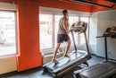 一个人做12-3-30在跑步机上锻炼在健身房。