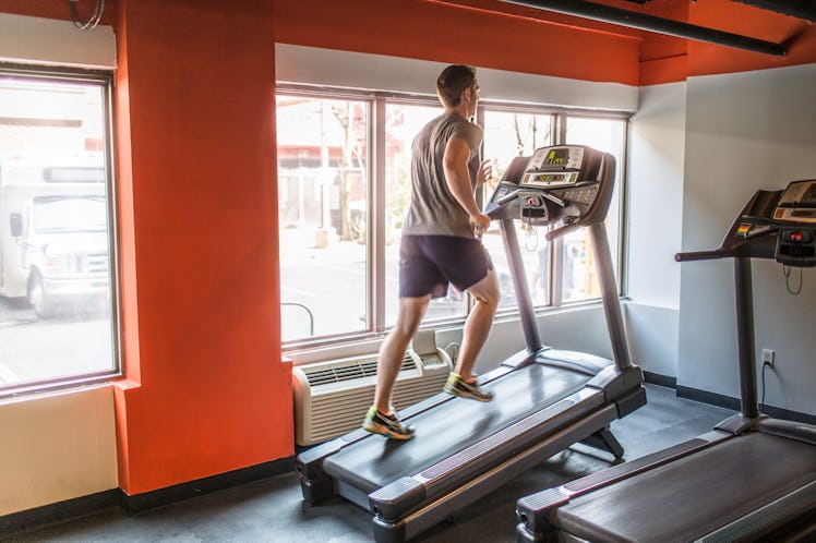 A man doing the 12-3-30 workout on a treadmill in a gym.