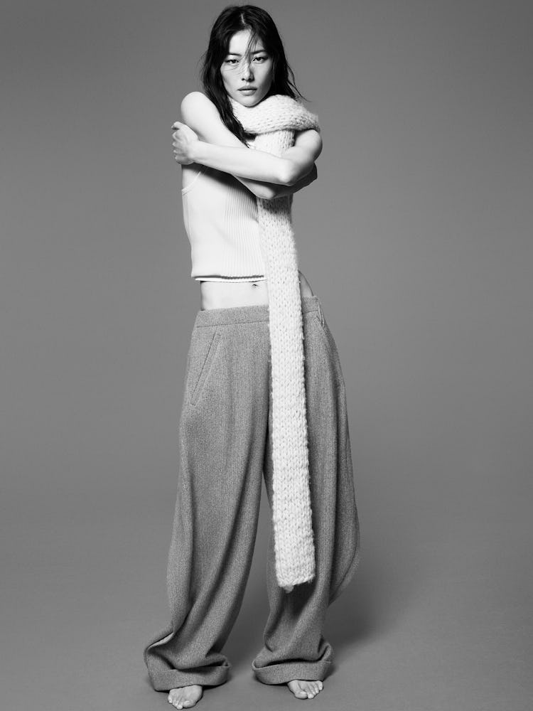 Model Liu Wen wears a white tank top, gray sweat trouser pants, and white knit scarf.