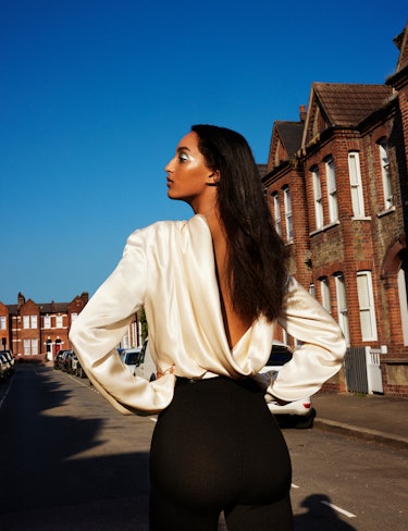 Model Mona Tougaard wears a ivory silk blouse, black pants, and belt.