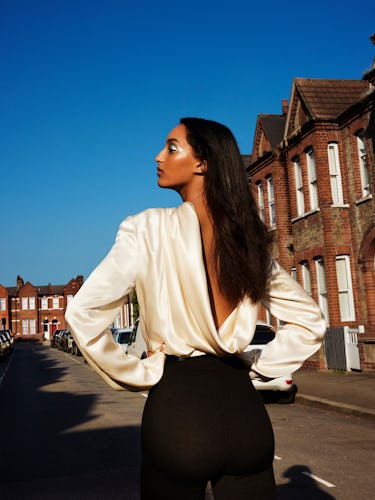 Model Mona Tougaard wears a ivory silk blouse, black pants, and belt.