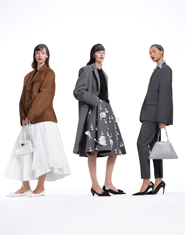 Models wears a white skirt, brown jacket; gray wool coat, gray skirt and black top; gray women's sui...