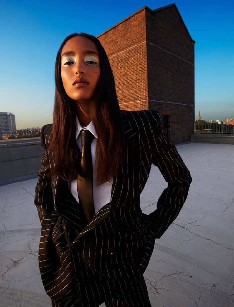 Model Mona Tougaard wears a black pinstripe suit; white button down shirt and black tie.