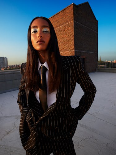 Model Mona Tougaard wears a black pinstripe suit; white button down shirt and black tie.