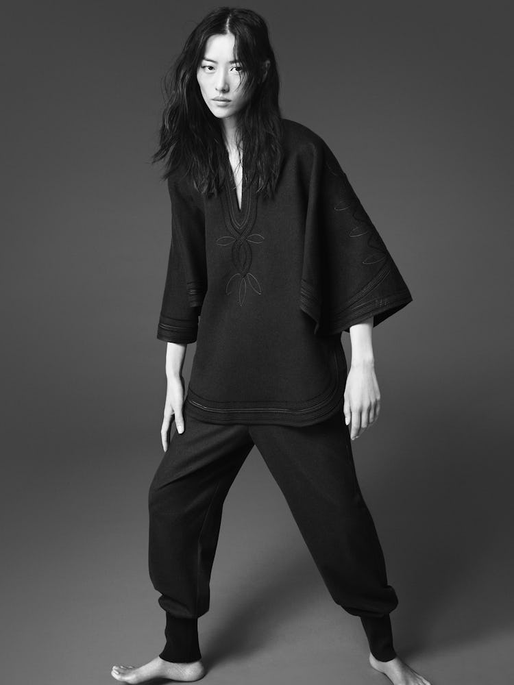 Model Liu Wen wears a black cape and black jogger pants.