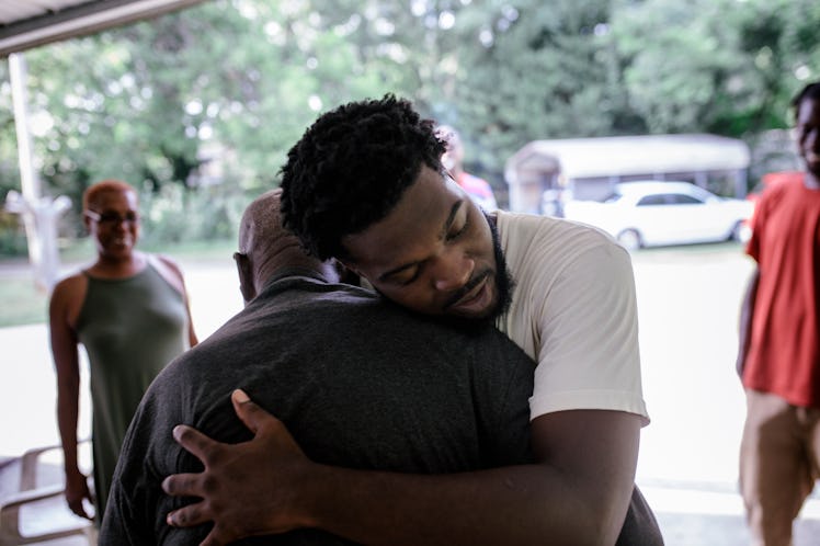 Two men hugging outdoors.