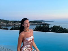 Dua Lipa posed in front of a pool.