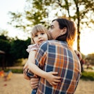 Father in plaid shirt holding young daughter in his arms