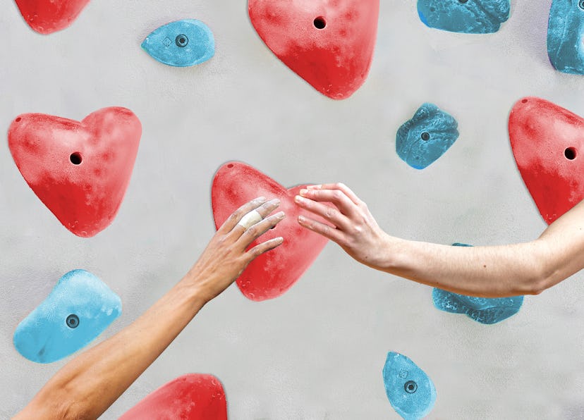 two hands about to touch on a rock climbing wall