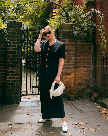 An editor wears a maxi skirt, a fall 2023 trend, in black, with a black buttoned top 