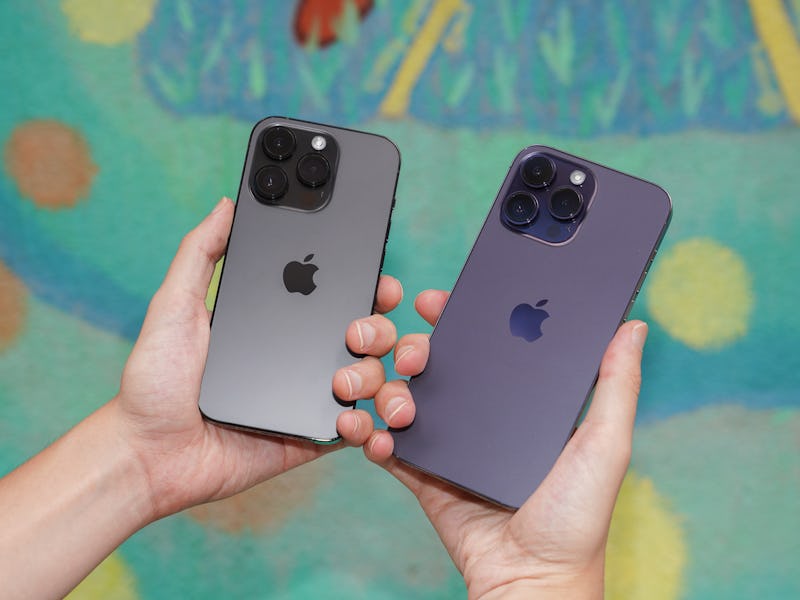 Inverse senior editor James Pero holding Apple's iPhone 14 Pro in Space Black and the iPhone 14 Pro ...