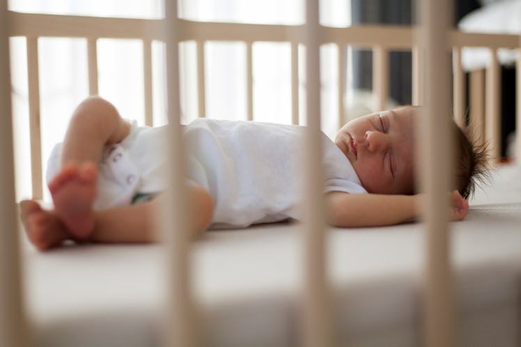 A baby sleeping in their crib.