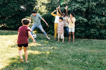 A family plays kickball.