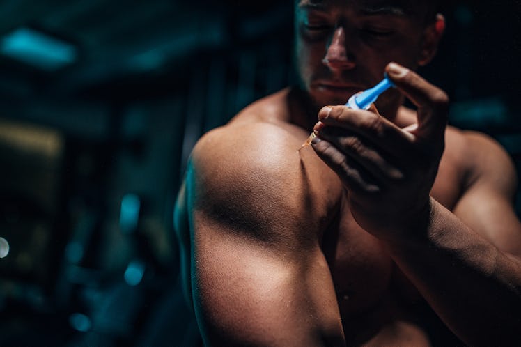 A muscular man injecting testosterone.