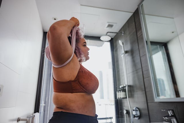 A large-chested woman takes off her shirt.