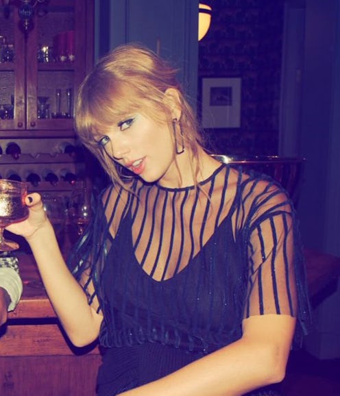 Taylor Swift messy bangs holding cocktail