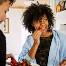 A man and woman eating strawberries at home to lower their blood sugar levels.