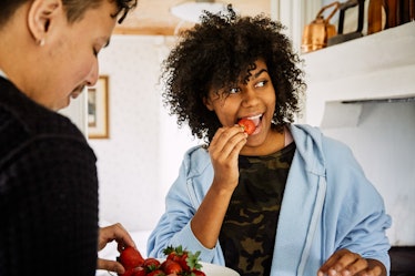 A man and woman eating strawberries at home to lower their blood sugar levels.