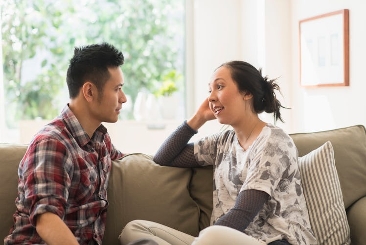 Man and woman sitting on a couch having a serious conversation