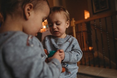 Two toddlers fighting over a toy.