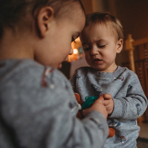 Two toddlers fighting over a toy.