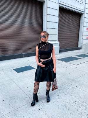 kelsey stiegman wears a pleated leather skirt, sheer artizia top, Caledonia rose tights, and maison ...