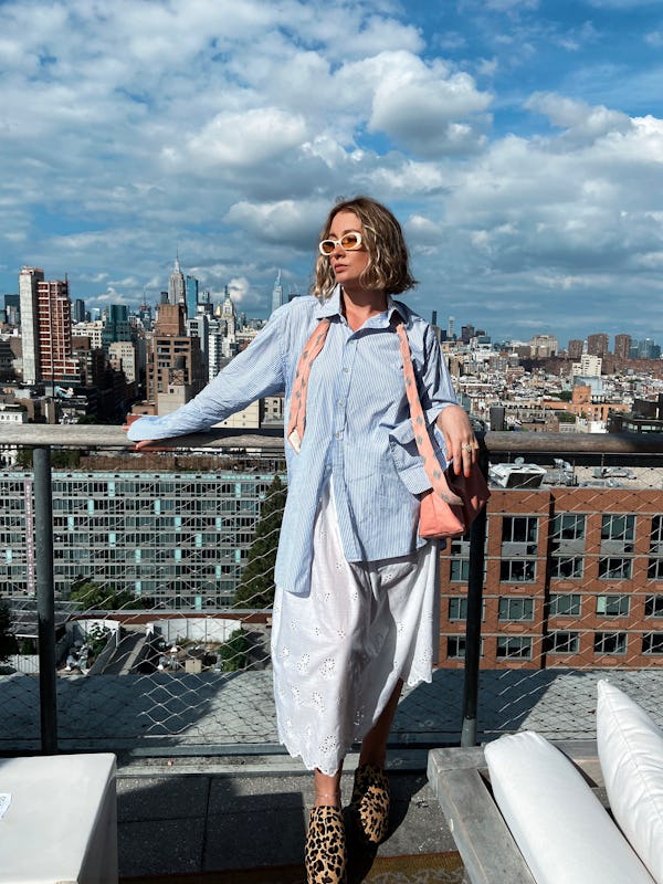 kelsey stiegman wears a blue pin-stripe button-up and eyelet skirt at new york fashion week septembe...