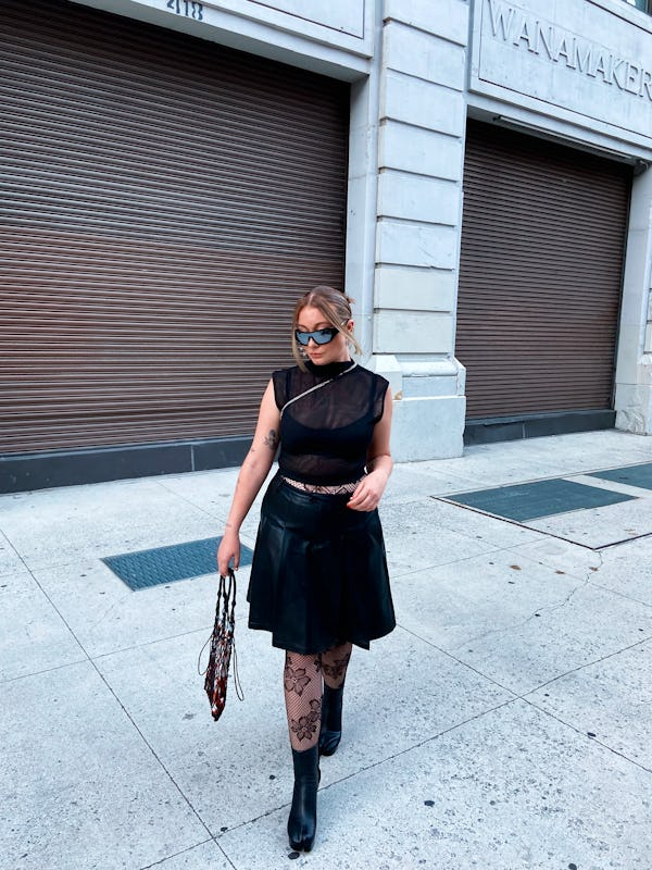 kelsey stiegman wears a pleated leather skirt, sheer artizia top, Caledonia rose tights, and maison ...