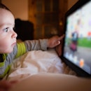 A 1-year-old having screen time by playing a game on a tablet.