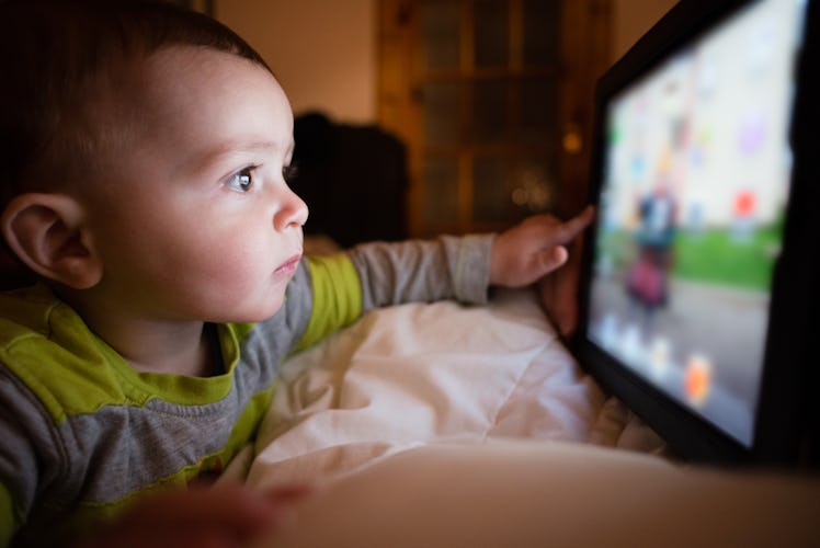 A 1-year-old having screen time by playing a game on a tablet.
