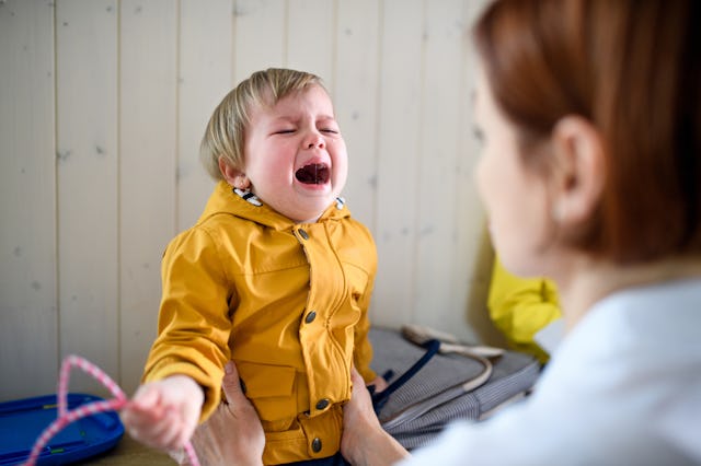 Child with separation anxiety cries as mother consoles them.