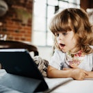 A toddler stares at a tablet that is tracking her eyes for autism diagnosis.