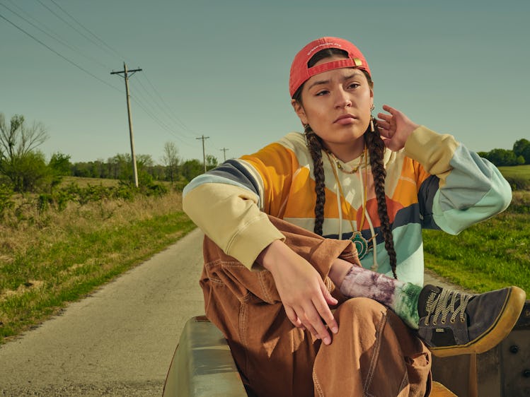 Paulina Alexis as Willie Jack, in a backwards hat and braids, riding in the back of a pickup truck