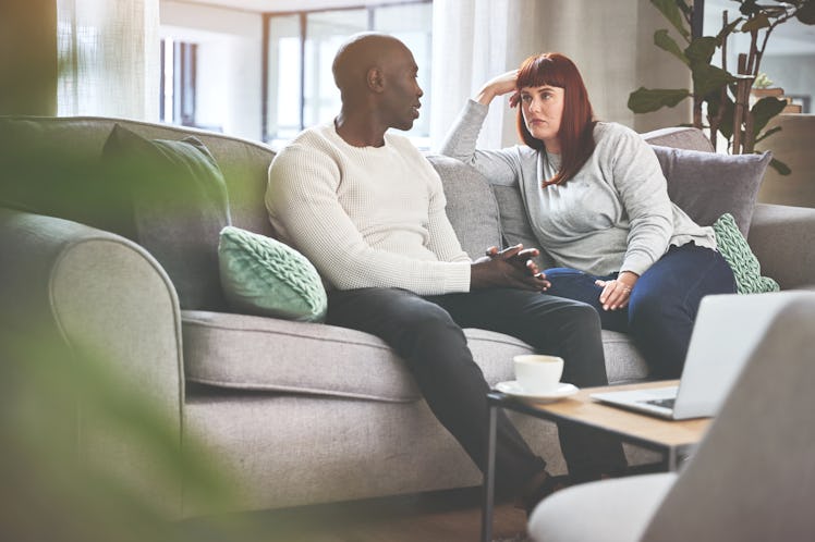 Couple on couch at home having a serious conversation