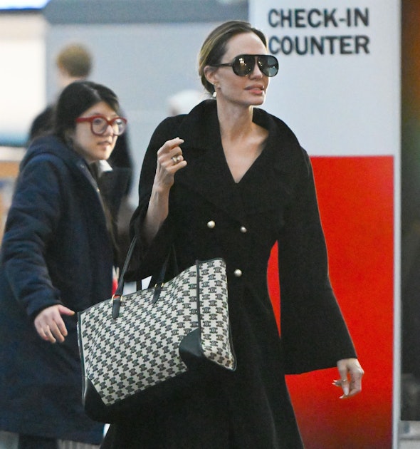Angelina Jolie nails airport style in black trench coat
