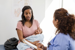A woman speaks with a nurse at her baby's well-check appointment.