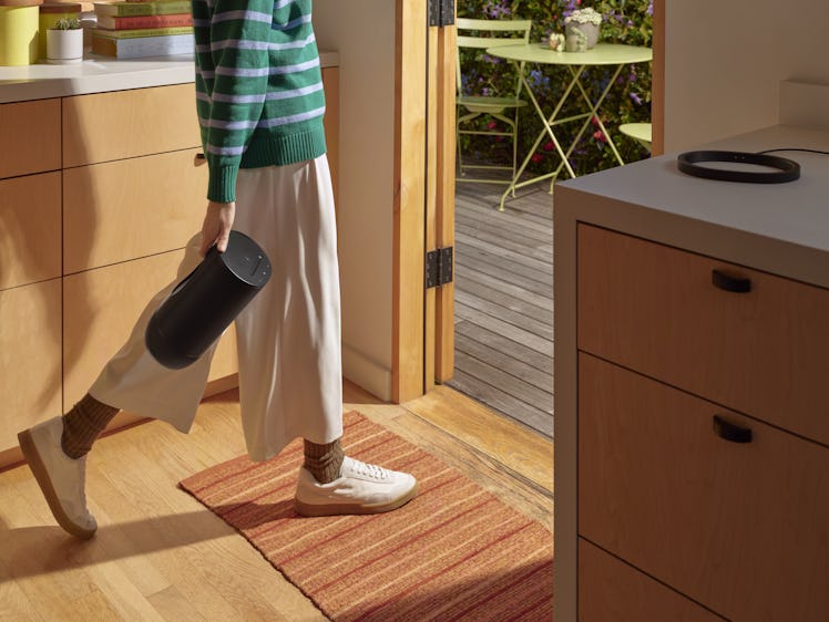 A person using the handle on the Sonos Move 2 to bring the speaker outside.