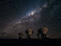 Four antennas of ALMA, the Atacama Large Millimeter/submillimeter Array. Across the image in the bac...