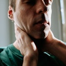 Close up of anxious man grabbing his neck.