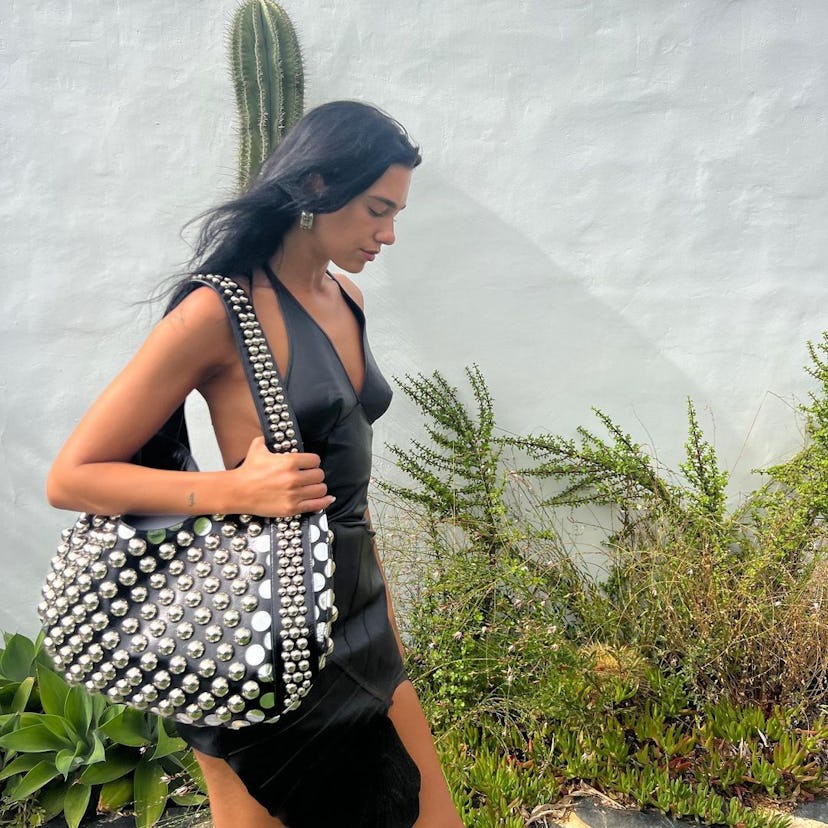 Dua Lipa wears a studded leather bag in a photo posted to her Instagram.
