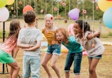 Kids play a bobbing for donuts party game in a story about kids birthday party games, crafts, and ac...